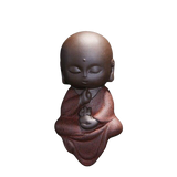 statue bouddha méditation rouge chauve sur fond blanc